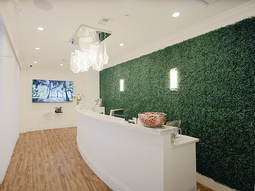 Modern reception area with greenery and lighting.