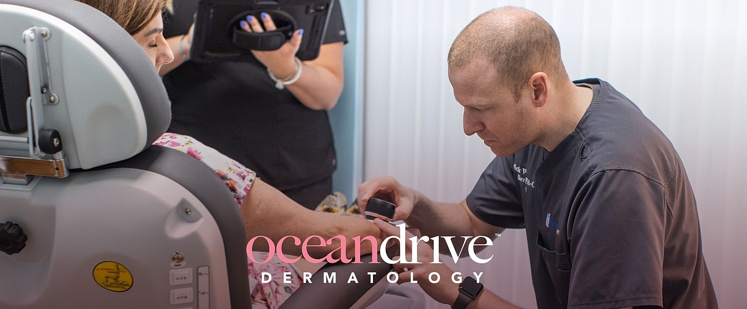 Dermatologist examining patient's arm in clinic.