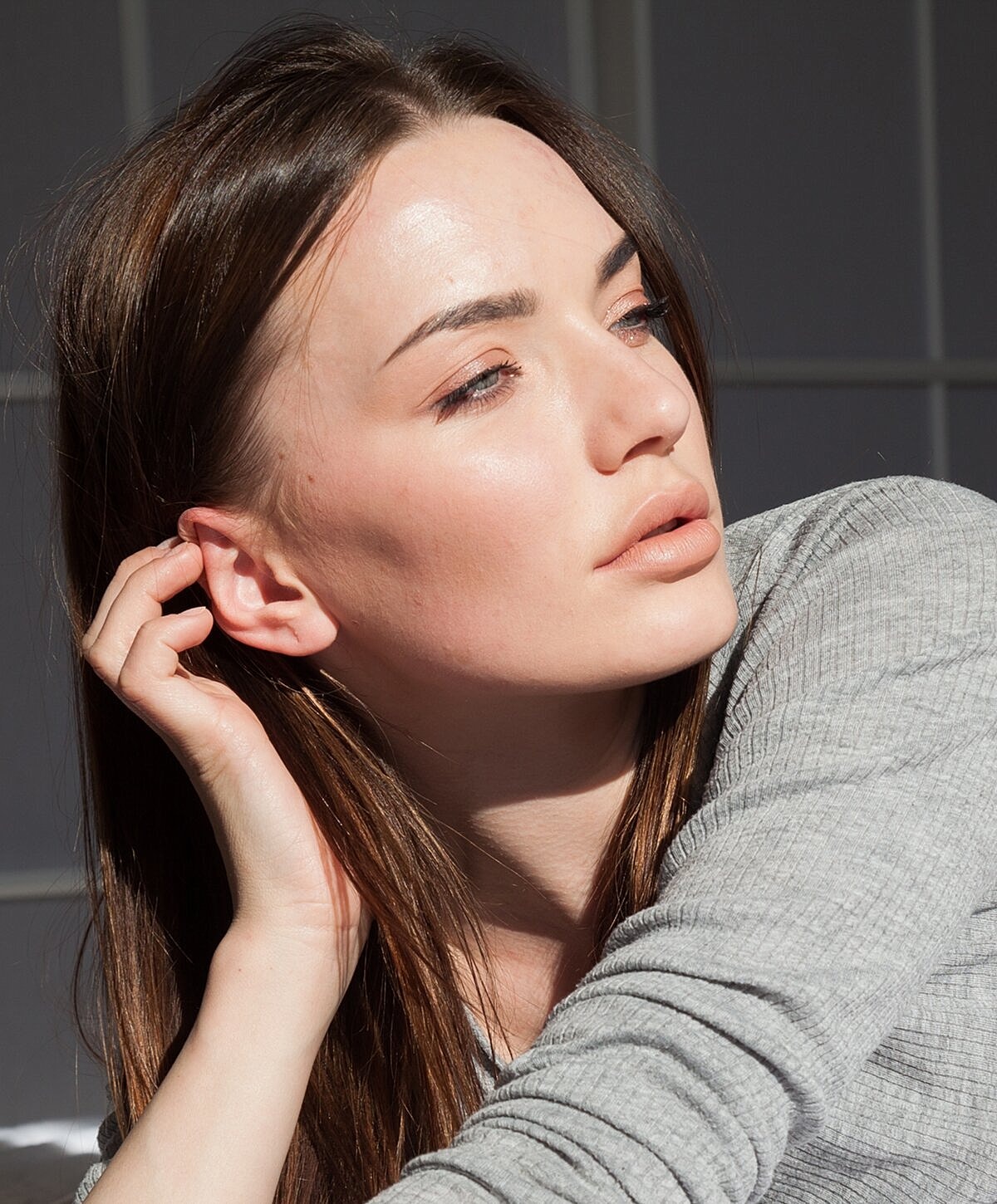 Woman relaxing by a pool, serene expression.