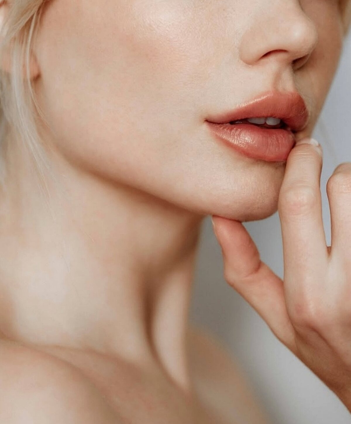 Woman with wet hair sitting on the beach.