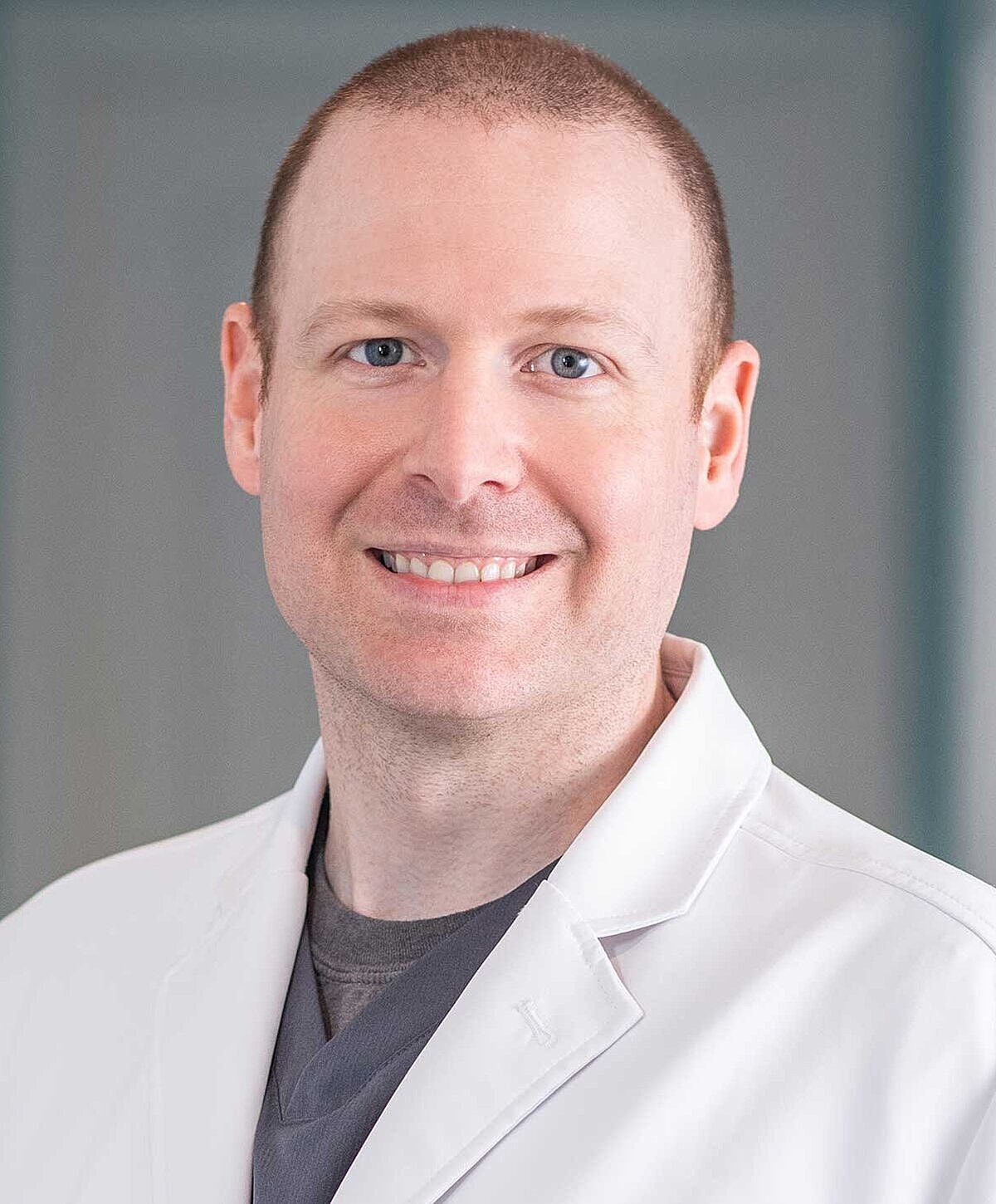 Smiling healthcare professional in a white coat.