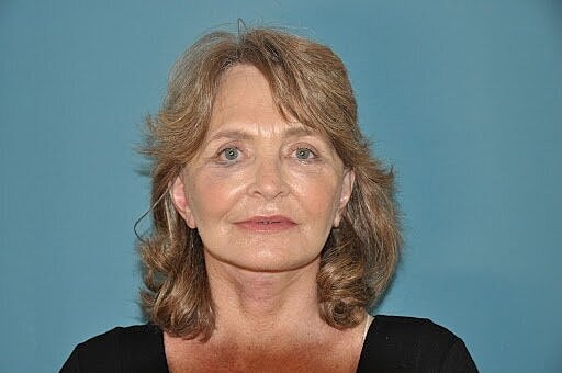 Woman with medium-length hair against blue background.