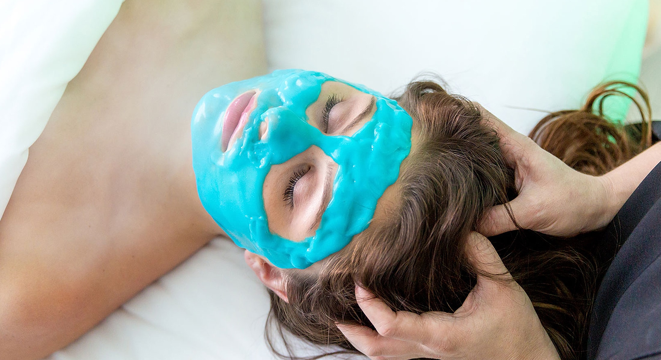 Person receiving facial mask treatment and relaxation.