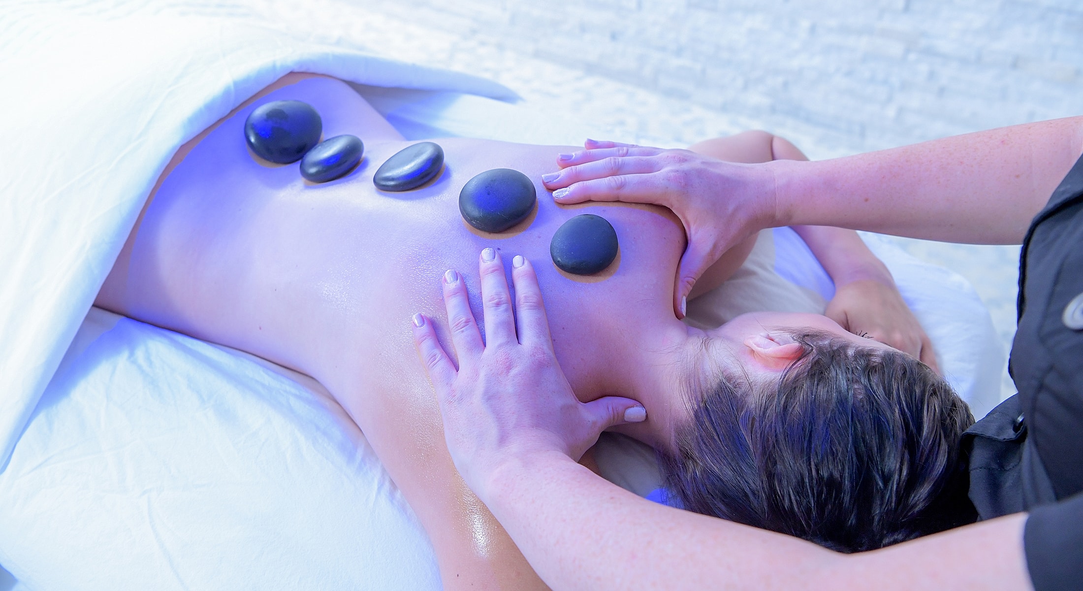 Hot stone massage therapy in serene setting.